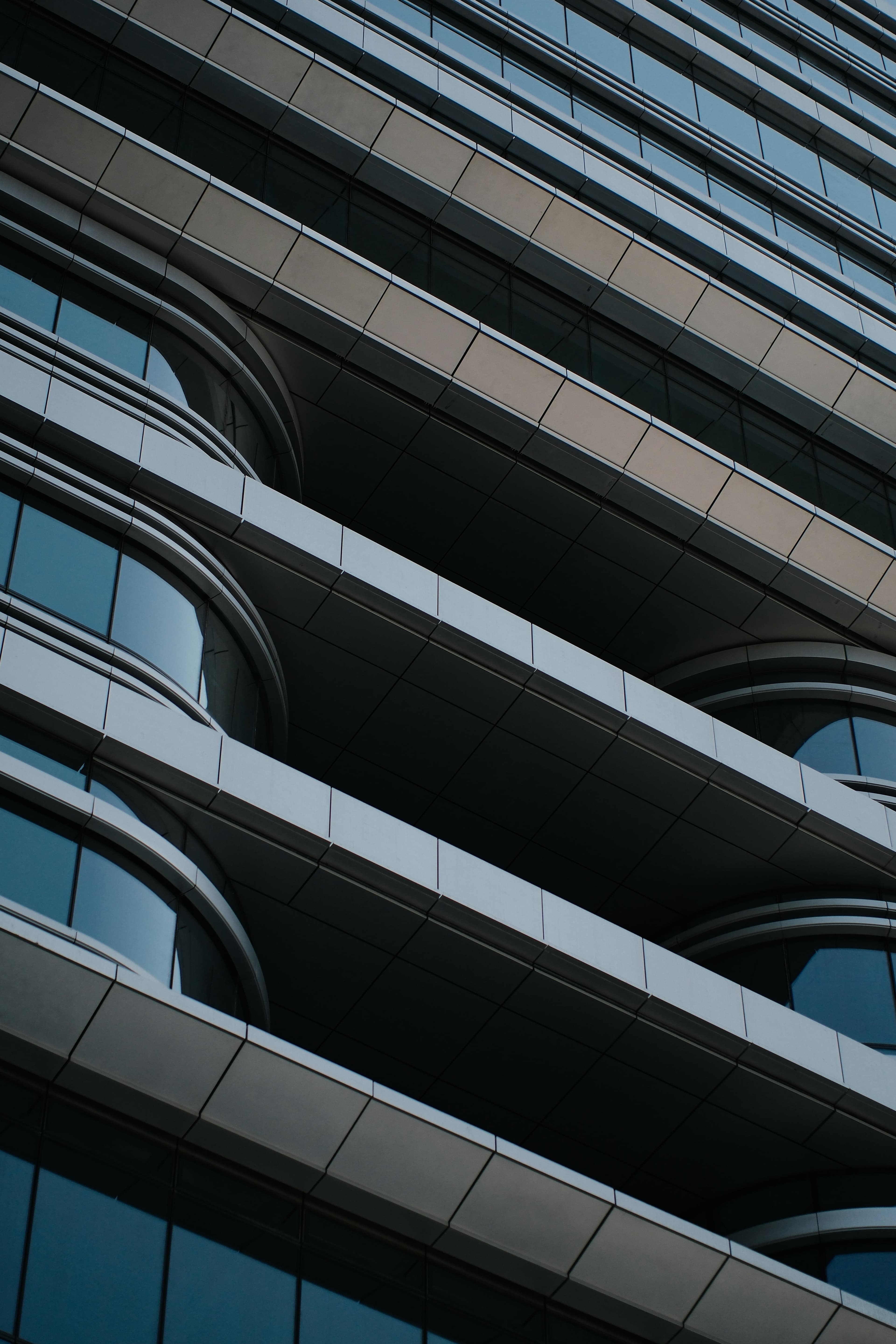 Looking up the facade of a modern office building, in warm monochrome