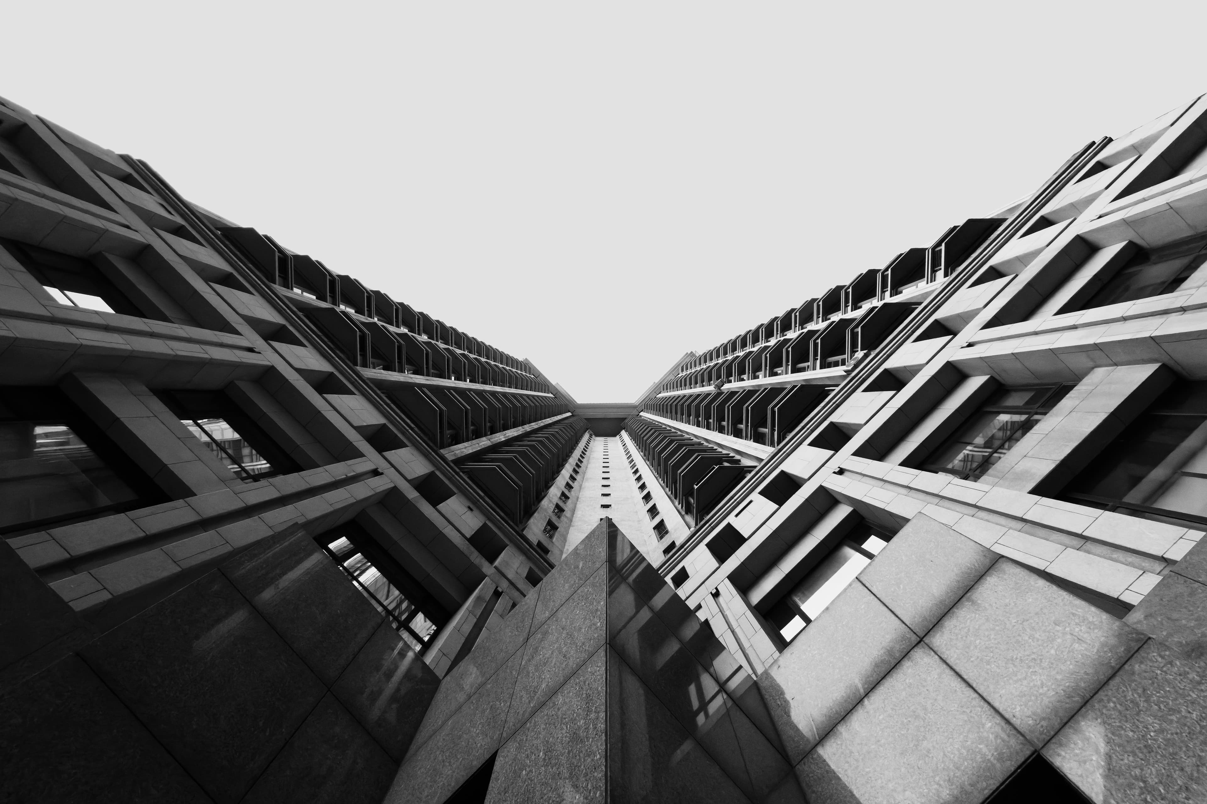 Skyscraper towering over neighboring buildings, in warm monochrome